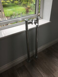 Chrome bath taps, before a bathtub was installed, in front of an open window, looking down on a garden from an upper floor