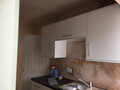A finished kitchen cupboard unit on a wall above a hob, without an oven extractor unit
